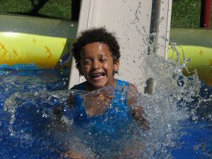 Swimming kid splashes into pool